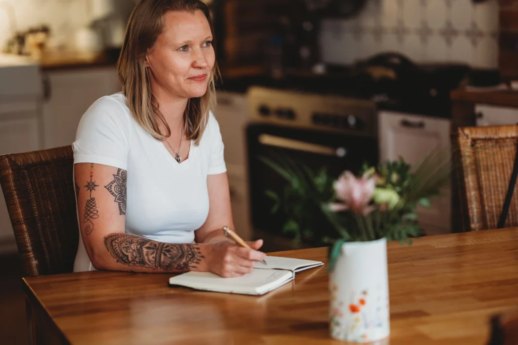 Kraftfeld Doula Mandy Heisterkamp Mertens sitzt am Tisch und macht sich Notizen